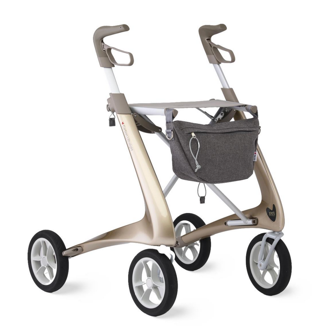 The ByACRE Ultralight Carbon Fiber Rollator (10.6 lbs) features ergonomic handles, a gray storage bag on the front frame, a metallic gold finish, and black wheels with white rims for a modern, stylish look.